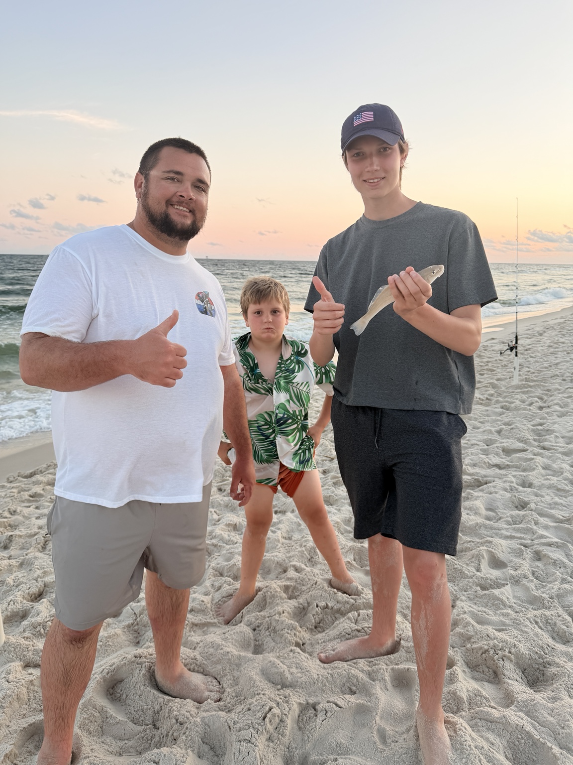 Family celebrating a catch while surf fishing on the Alabama Gulf Coast