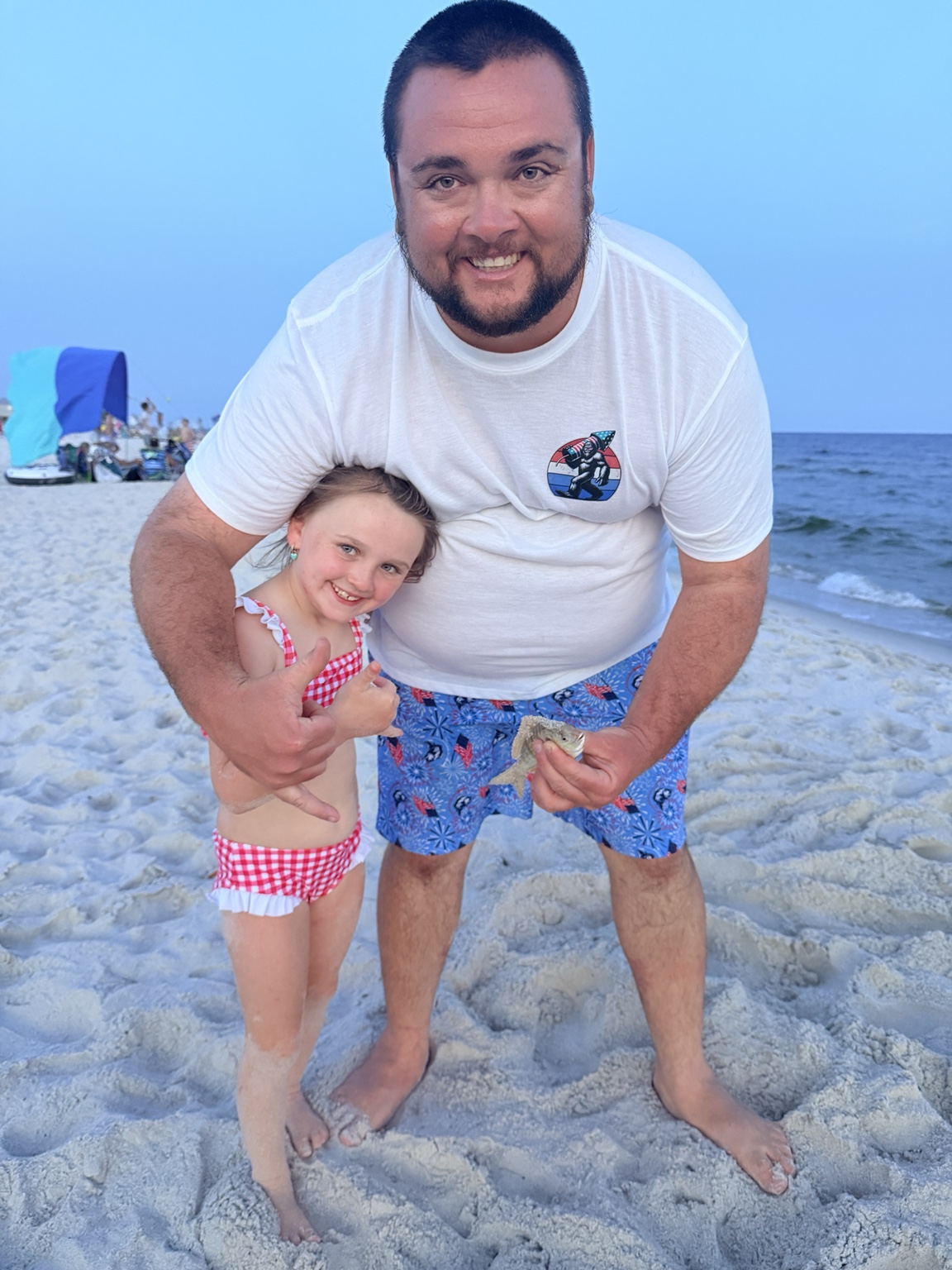 Father and daughter celebrating a small beach catch together