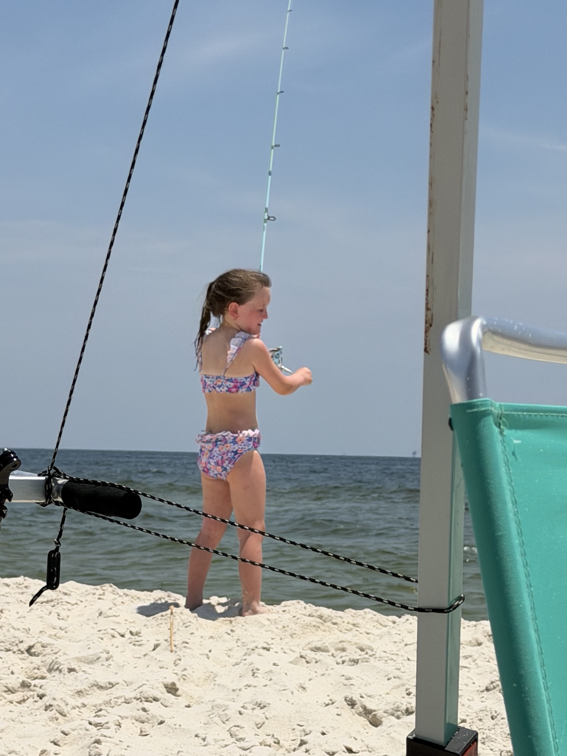 Young girl learning to cast from an Alabama beach