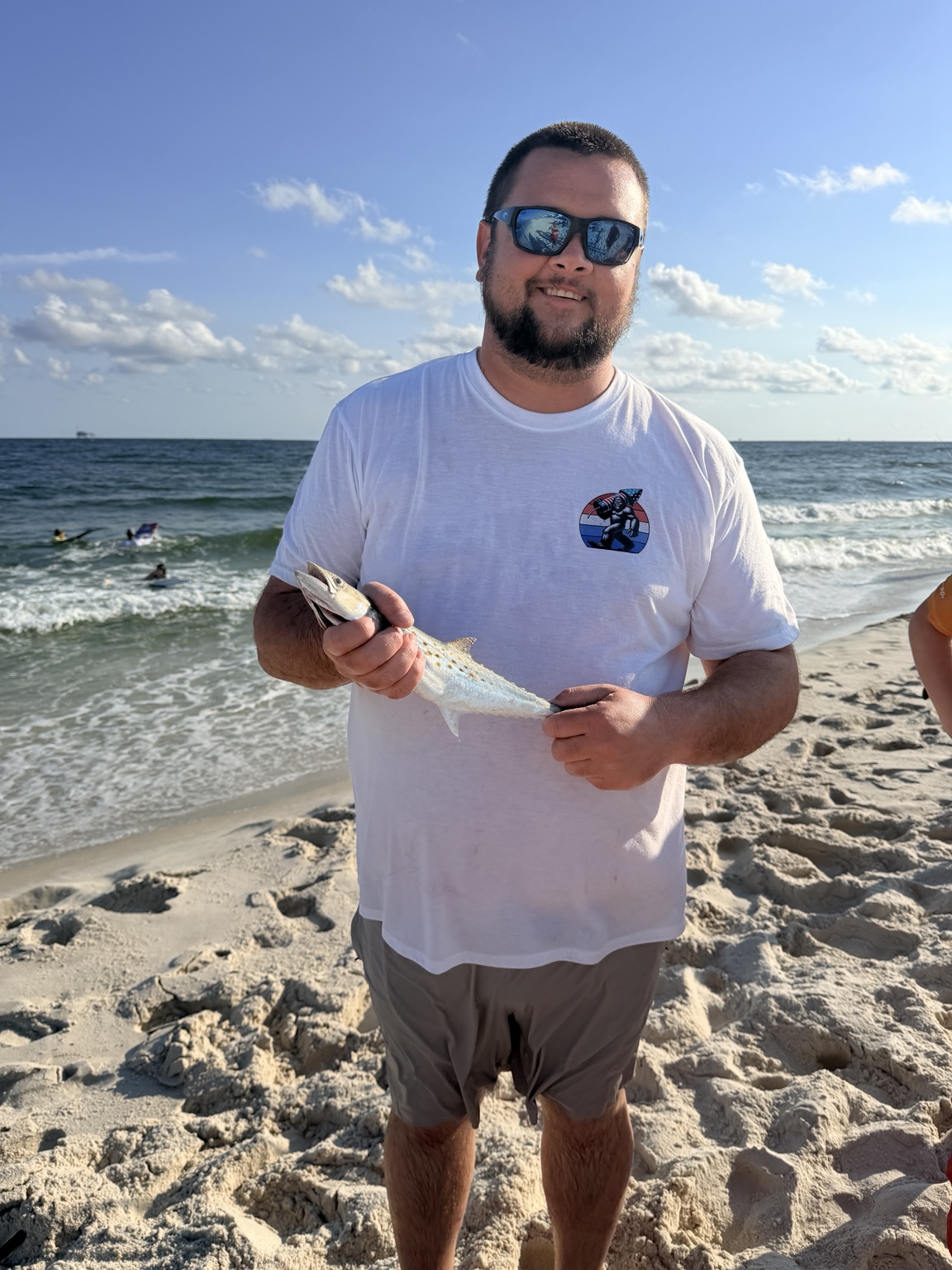 Angler holding a saltwater catch beside the Gulf